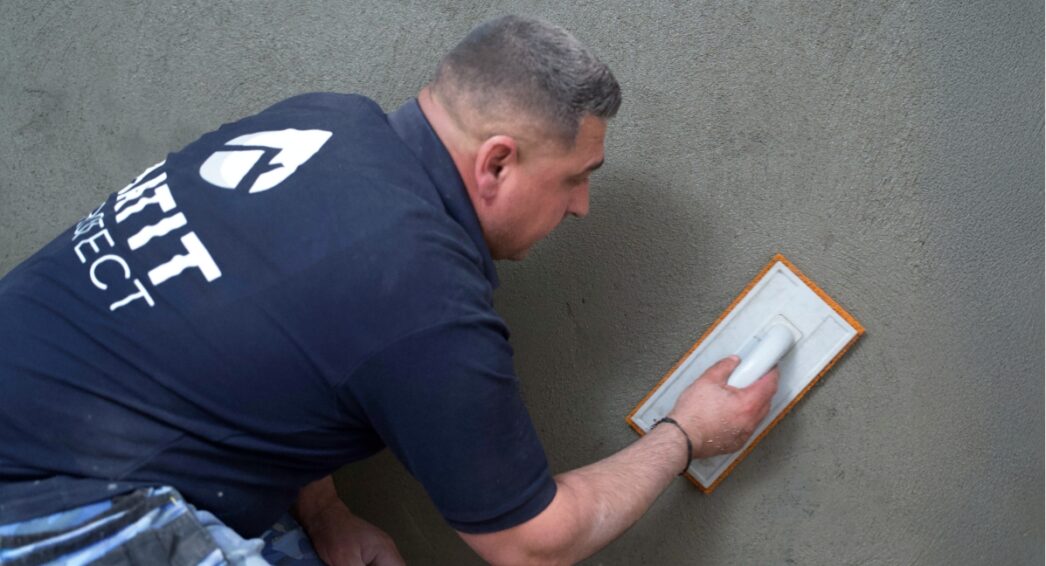 Technicien BATIT PROTECT appliquant un enduit sur mur de cave