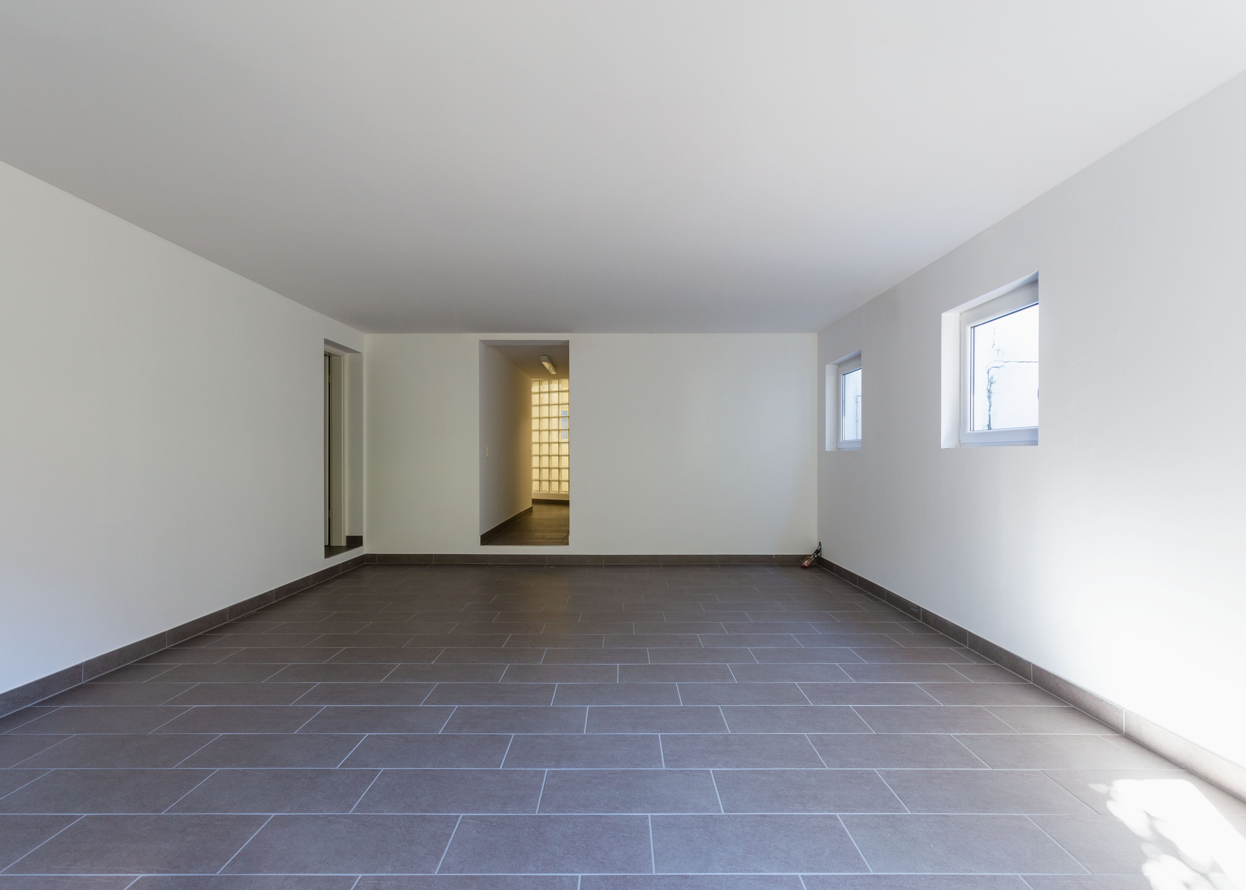 Pièce carrelée avec fenêtres affectée par l'humidité