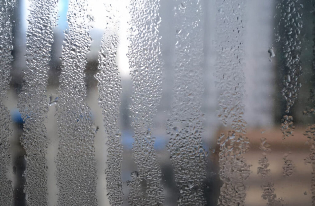 Gouttes d’eau sur vitre intérieure d’une fenêtre dues à un excès d’humidité