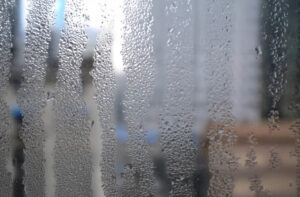 Gouttes d’eau sur vitre intérieure d’une fenêtre dues à un excès d’humidité