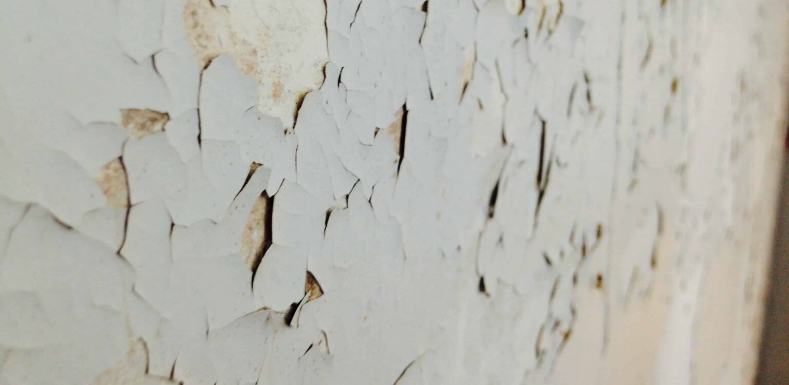 Mur abîmé par l’humidité avec cloques et peinture décollée